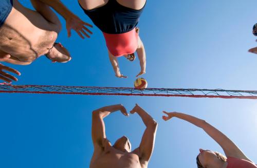 a group of people jumping in a volley ball net at Maistra Select Petalon Resort in Vrsar