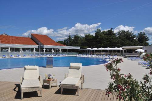 a swimming pool with lounge chairs and a resort at Maistra Select Petalon Resort in Vrsar