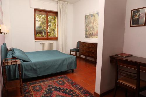 una camera con letto, scrivania e finestra di B&B Alle Querce a San Giovanni Rotondo