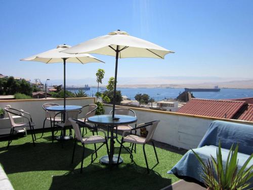 卡爾德拉的住宿－El Faro，屋顶上配有2张桌子和椅子及遮阳伞