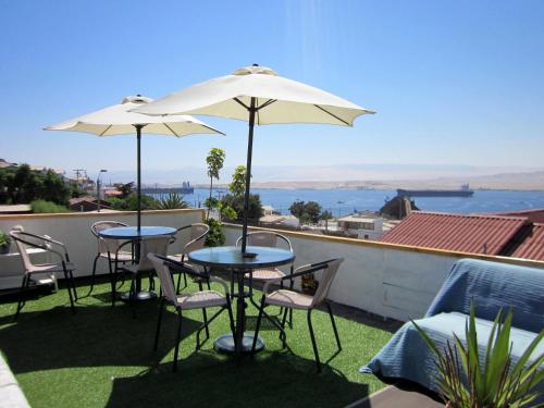 two tables and chairs with umbrellas on a roof at El Faro in Caldera