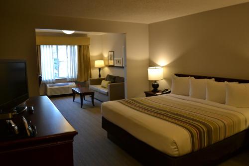 a hotel room with a bed and a couch at Country Inn & Suites by Radisson, Gurnee, IL in Gurnee