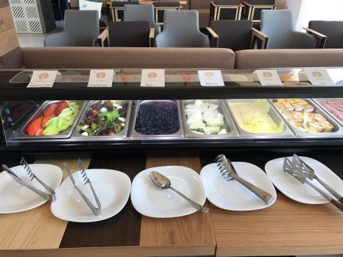 a display case with white plates and silver utensils at St. Panteleimon Beach Hotel in Nesebar