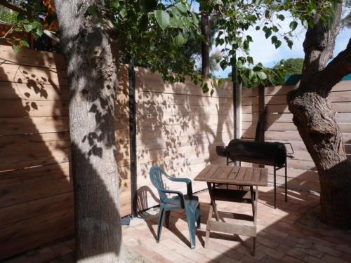 a patio with a table and chairs and a grill at El Tamarisco in Puerto Pirámides