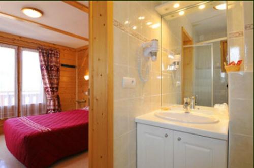 La salle de bains est pourvue d'un lavabo et d'un miroir. dans l'établissement Le Choucas, à Châtel