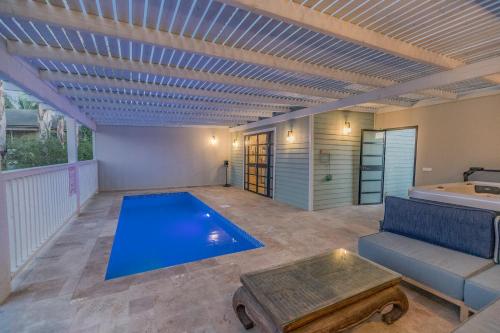 a swimming pool in a living room with a couch and a table at Gold 68- גולד 68 סוויטות בוטיק in Kefar Barukh