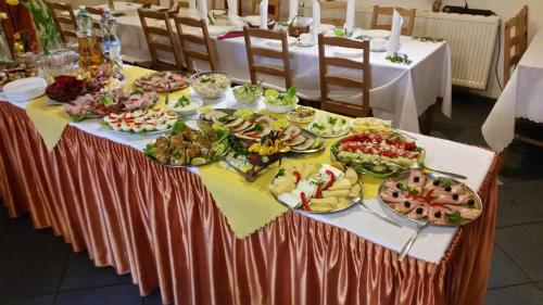 une table avec de nombreuses assiettes de nourriture dessus dans l'établissement Ośrodek Wypoczynkowy Evita, à Krynica-Zdrój