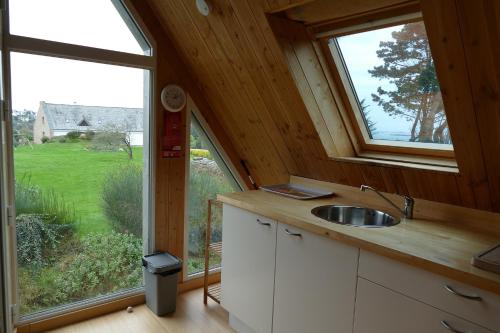 a kitchen with a sink and a large window at Cosmeur B&B in Carantec