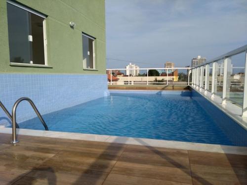 a swimming pool on the side of a building at Condominio Garden Indaia in Caraguatatuba