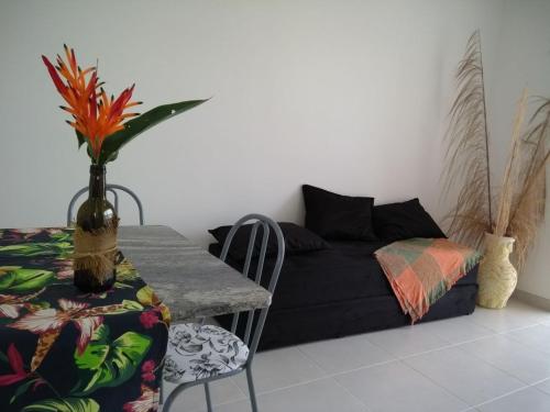 a living room with a table and a couch at Condominio Garden Indaia in Caraguatatuba