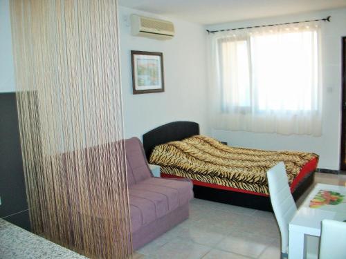 a bedroom with a couch and a bed and a window at Apartments Petrovic in Krimovice