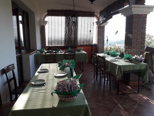 a dining room with green tables and chairs and windows at Agriturismo Arena Del Sol in Fertilia
