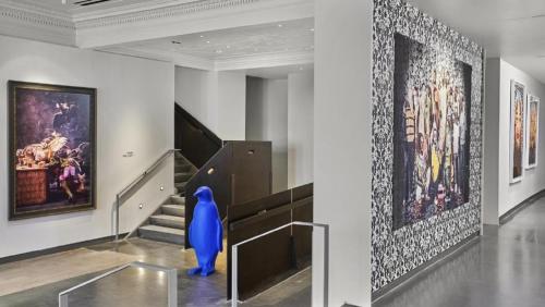 a hallway with a staircase with paintings on the wall at 21c Museum Hotel Lexington in Lexington