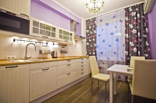 モスクワにあるLakshmi Apartment Novy Arbat 1kのキッチン(白いキャビネット、ダイニングテーブル付)