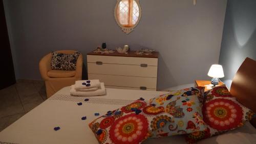 a bedroom with a bed and a dresser and a chair at Finestra sul Mare in Terme Vigliatore