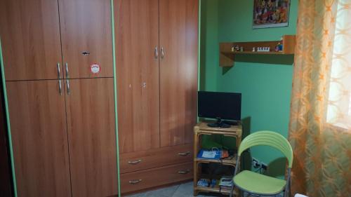 a bedroom with a large wooden cabinet and a television at Finestra sul Mare in Terme Vigliatore