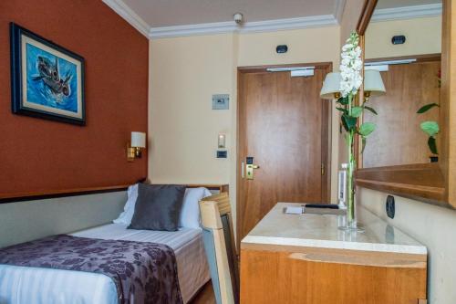 a small room with a bed and a sink at Hotel Giolli Nazionale in Rome