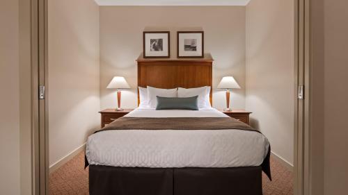 a hotel room with a large bed with two lamps at Best Western PLUS Chemainus Inn in Chemainus