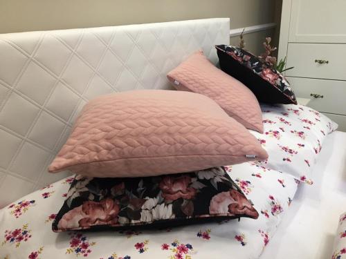 two pink pillows sitting on a bed at Family & Business Sauna Apartments Sienkiewicza No1 Centrum Plac Lliteratów- Piękny Apartament - 1 Bedroom with Private Sauna, Bath with Hydromassage, Parking in Kielce