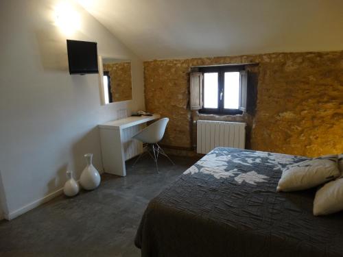 a bedroom with a bed and a desk and a window at Hotel Raimblanc in Villargordo del Cabriel