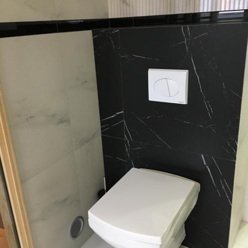 a bathroom with a white toilet and a black wall at Family & Business Sauna Apartments Sienkiewicza No1 Centrum Plac Lliteratów- Piękny Apartament - 1 Bedroom with Private Sauna, Bath with Hydromassage, Parking in Kielce