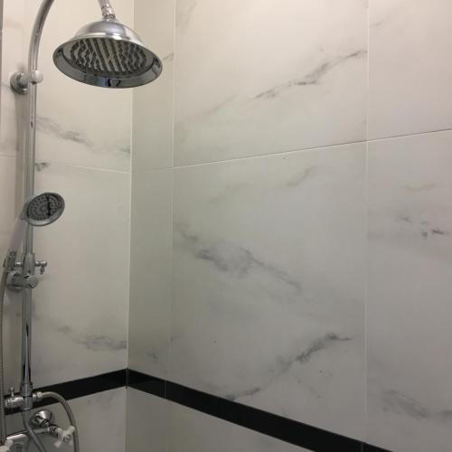a bathroom with a shower with white marble walls at Family & Business Sauna Apartments Sienkiewicza No1 Centrum Plac Lliteratów- Piękny Apartament - 1 Bedroom with Private Sauna, Bath with Hydromassage, Parking in Kielce