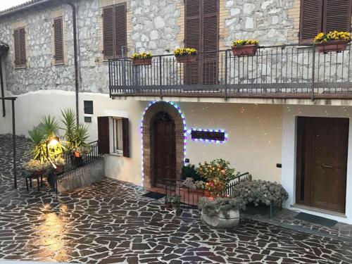 カンペッロ・スル・クリトゥンノにあるB&B Le Torretteのドアと花の咲くバルコニー付きの建物