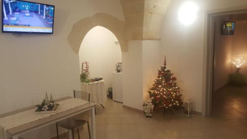 a christmas tree in a living room with a tv at ALIMAR B&B in Lizzano