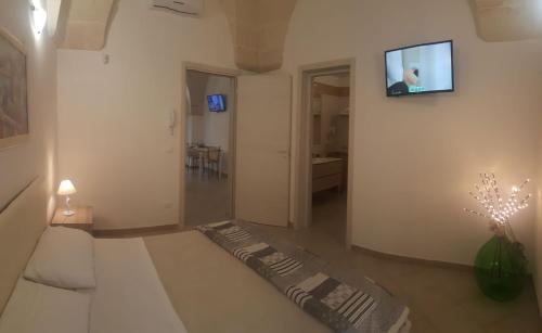 a living room with a television on a wall at ALIMAR B&B in Lizzano