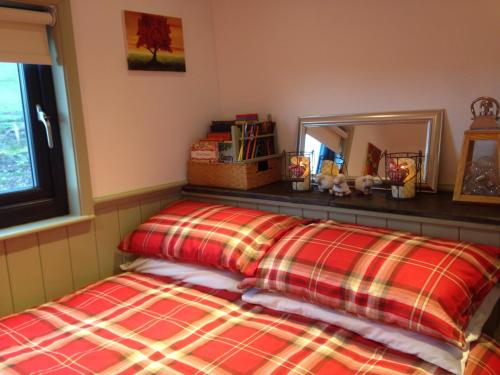 um quarto com uma cama e um espelho em Upper Gilwern Quarry Hut em Llandrindod Wells