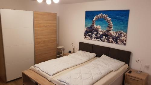 Bett in einem Zimmer mit Wandgemälde in der Unterkunft Ferienwohnung Dünenperle in Juliusruh