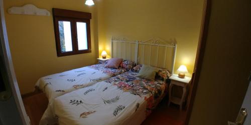 1 dormitorio con 1 cama, 2 lámparas y ventana en Casa Sierra, en Candelario