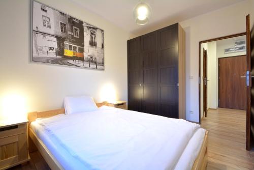 een slaapkamer met een groot wit bed en een kast bij Apartament Bema 38 in Wrocław