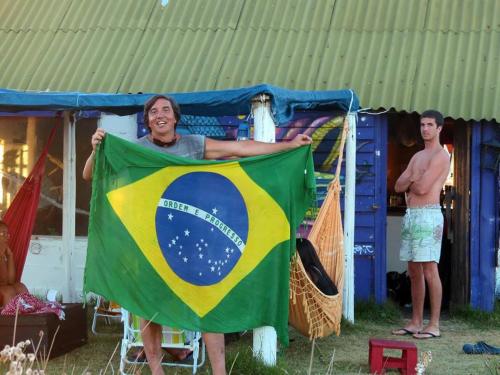 a man holding a brazilian flag in a tent at cabopolonioalojamiento in Cabo Polonio