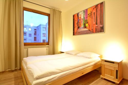 a bedroom with a bed and a window at Apartament Bema 37 in Wrocław