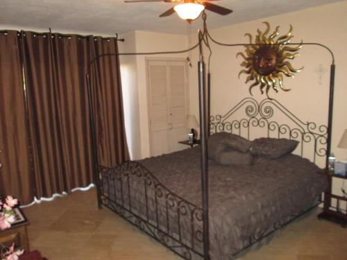 a bedroom with a metal canopy bed with a fan at Pinacate Marina Resort - Villa 11 in Puerto Peñasco