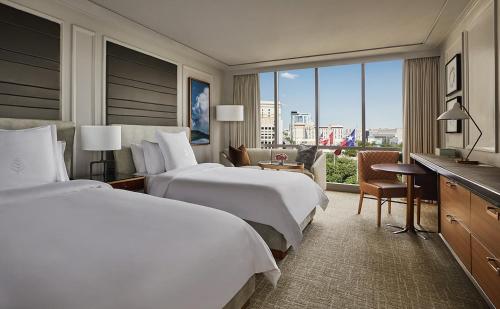 two beds in a hotel room with a view at Four Seasons Hotel Austin in Austin