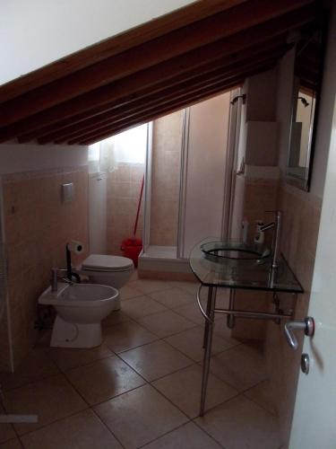 a bathroom with a toilet and a glass table at La casa di Oliva in Macerata