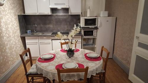 uma cozinha com uma mesa e um frigorífico branco em la villa mersoise em Mers-les-Bains