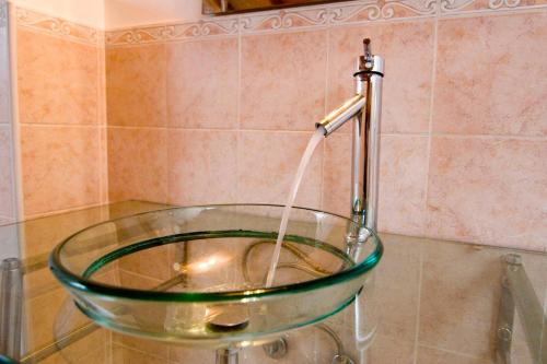 a glass sink in a bathroom with a faucet at La casa di Oliva in Macerata