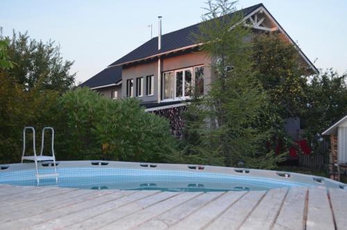 a house with a swimming pool in front of a house at Чудо-Дом для Чудо-Людей in Plakhtyanka