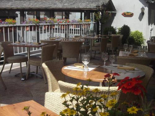 un restaurant avec des tables et des chaises sur une terrasse dans l'établissement Logis Auberge de l'Isard, à Saint-Lary