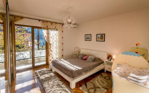 a bedroom with a bed and a large window at Nina in Herceg-Novi
