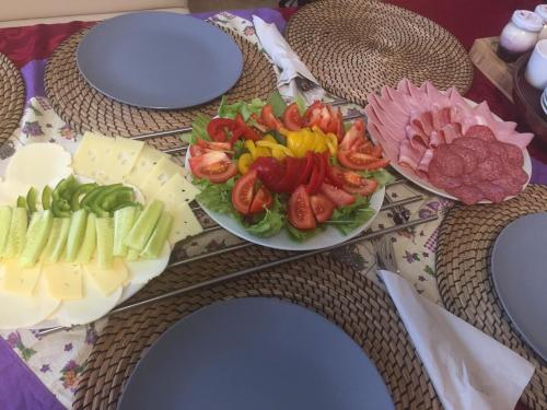 een tafel met een bord groenten en kaas bij Ezathouse Devičie in Krupina