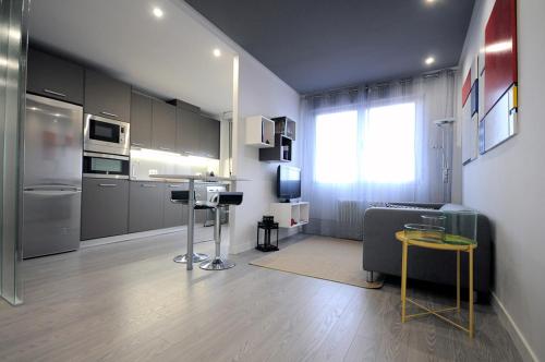 cocina con electrodomésticos de acero inoxidable y sala de estar. en el11 apartamento en Zamora