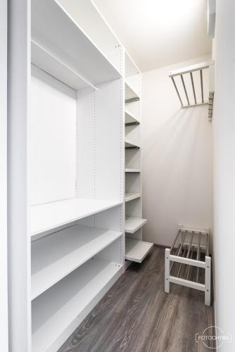 a closet with white shelves and a stool at Klinak horsky dum 140 in Loučná pod Klínovcem