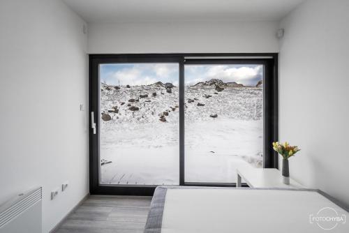 - une chambre avec une grande fenêtre offrant une vue sur la montagne dans l'établissement Klinak horsky dum 140, à Loučná pod Klínovcem