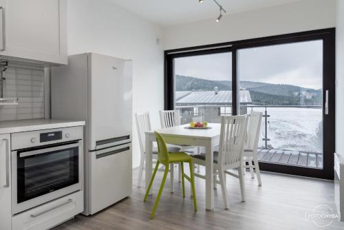 a kitchen with a table and chairs and a window at Klinak horsky dum 140 in Loučná pod Klínovcem