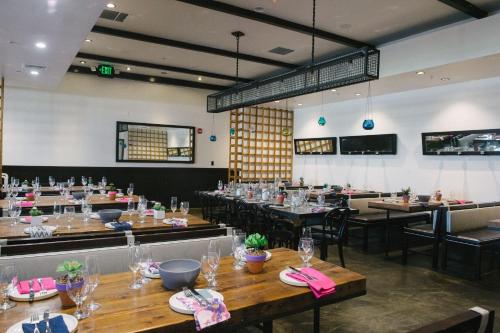 a dining room with wooden tables and chairs at The Saguaro Palm Springs in Palm Springs