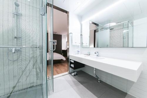 a bathroom with a sink and a shower and a mirror at Golden River Hotel in Gwangmyeong